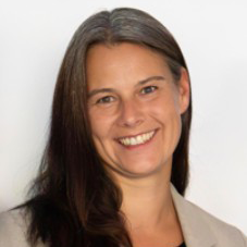 Manuela Jähn von AXA lächelt in die Kamera vor neutralem Hintergrund