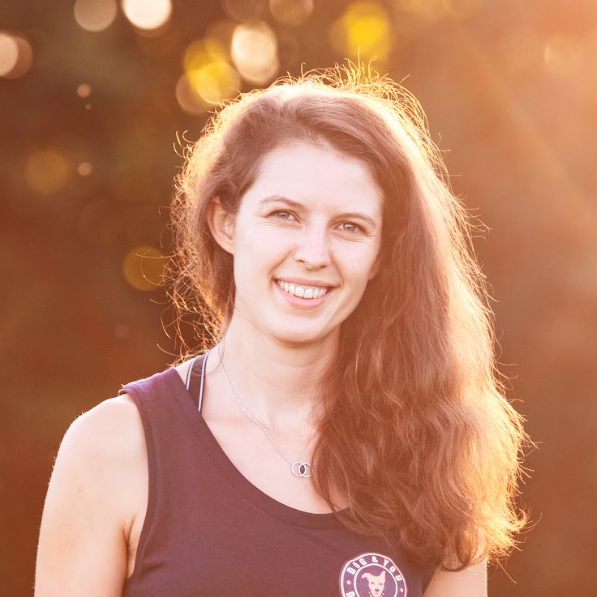 Selina Brandl, Inhaberin von Dog & You, lächelt im Sonnenlicht und trägt ein Top mit Logo